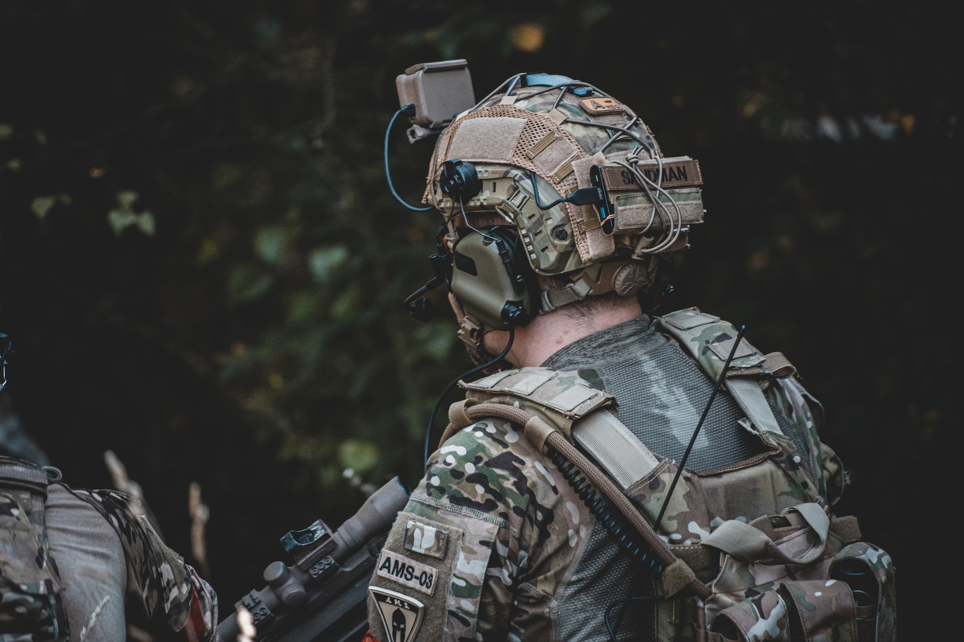 man in black and brown camouflage jacket wearing helmet and helmet